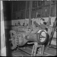Oran. Ateliers et fonderies Célestin Ducros (AFCD). Ouvrier travaillant sur la chaîne de montage des tracteurs.