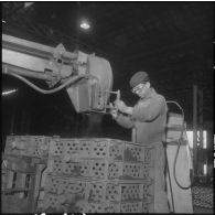 Oran. Ateliers et fonderies Célestin Ducros (AFCD). Ouvrier faisant les moules à la sableuse à haute pression.