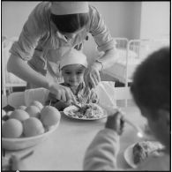 Tlemcen. Hôpital civil. Une femme donne à manger à un enfant.
