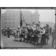Metz (Lorraine). Voyage de Mr Poincaré. Jeunes Messines encadrant le porte-drapeau d'un régiment et acclamant Mr Poincaré. [légende d'origine]