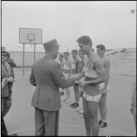 Alger. Stade Marcel Cerdan. Finale d'Afrique du Nord (AFN) de basketball. Le Général Vandeuil remet la coupe à l'équipe gagnante : le 45e régiment du train (RT).