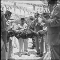 Le général Gambiez et le député d'Alger Kaouah, entourés des officiers dégustent le méchoui.