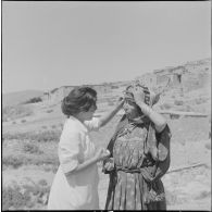 Un membre de l'équipe médico-sociale itinérante (EMSI), soignant une femme.