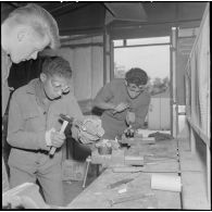 L'élève apprend à se servir du burin, sous l'oeil vigilant du maître.