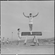 Démonstration d'exercice de voltige au cheval d'arçon.