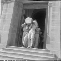 Des militaires, appartenant au 27e dragon, portant le cercueil sur leurs épaules.