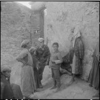 Section administrative spécialisée (SAS) d'Akourma. Dans le village de Tirarmine perdu dans le djebel, les moghaznis de la SAS discutent amicalement avec les habitants, femmes et enfants.