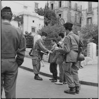 Alger. Des soldats fouillent un homme dans la rue.