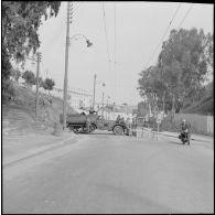 Alger. Barrage dans une rue surveillée par des soldats.