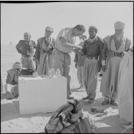 El Oued. Un chef de peloton donne des soins à un méhariste blessé.