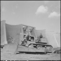 Barrage d'Erraguene et centrale. Un ouvrier à bord d'un engin de terrassement.