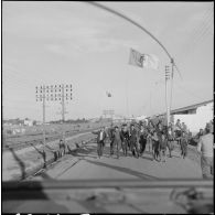 Bône. Manifestations. Aux "Lauriers Roses" les manifestants vont au devant de la Jeep avec l'emblème du Front de libération national (FLN).