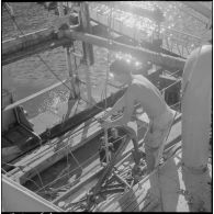 Mers el-Kébir. Les membres de l'équipage, pour la plupart marins appelés, hissent l'ancre à bord de la vedette côtière P755.