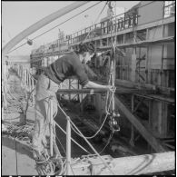 Mers el-Kébir. Les membres de l'équipage, pour la plupart marins appelés, hissent l'ancre à bord de la vedette côtière P755.