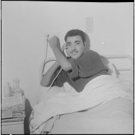 Alger. Clinique du centre hospitalier de la Madeleine. Un malade dans sa chambre en train d'écouter la radio.