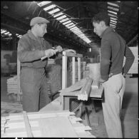 Sidi Chami. Menuiserie Lyon-Standard. Un moniteur montre à un jeune ouvrier la façon d'assembler une fenêtre.