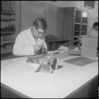 Camp de L'Alma (camp Bonvalot). Centre d'instruction du service du matériel n°3 (CISM n° 3). Un soldat travaillant sur des pièces en cours d'optique.