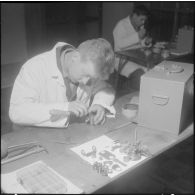 Camp de L'Alma (camp Bonvalot). Centre d'instruction du service du matériel n°3 (CISM n° 3). Un soldat travaillant sur des pièces en cours d'optique.