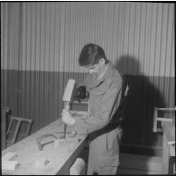Camp de L'Alma (camp Bonvalot). Centre d'instruction du service du matériel n°3 (CISM n° 3). Un soldat travaillant sur une pièce en bois.