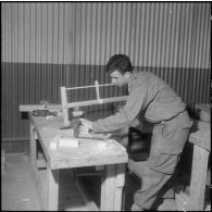 Camp de L'Alma (camp Bonvalot). Centre d'instruction du service du matériel n°3 (CISM n° 3). Un soldat sciant une pièce en bois.