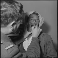 Aïn Temouchent. Le médecin aspirant regarde la gorge d'un malade.