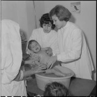 Aïn Temouchent. Une membre de l'équipe médico-sociale itinérante montre à une mère comment faire la toilette de son bébé.