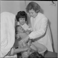 Aïn Temouchent. Une membre de l'équipe médico-sociale itinérante montre à une mère comment faire la toilette de son bébé.