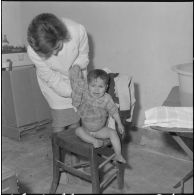 Aïn Temouchent. Une membre de l'équipe médico-sociale itinérante montre à une mère comment faire la toilette de son bébé.