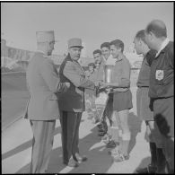 Stade municipal d'Alger. Finale des championnats interarmées de football. Le général Rafa remet la coupe au capitaine de l'équipe du 9e régiment de zouaves (RZ).