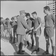 Stade municipal d'Alger. Finale des championnats interarmées de football. Le général Rafa félicite l'équipe du 2e GATAC (2e groupement aérien tactique adapté corps d'armée) d'Oran.
