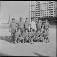 Stade municipal d'Alger. Finale des championnats interarmées de football. L'équipe gagnante du 9e régiment de zouaves (RZ) avec la coupe.