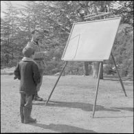 Tikdja. 22e bataillon de chasseurs alpins (BCA). L'instituteur donne une leçon devant un élève.