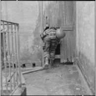Alger. L'armée boucle le quartier de Bab el Oued. Un soldat parachutiste inspecte derrière une porte en bois cassé.