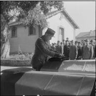 Alger. Chapelle de l'hôpital Maillot. Obsèques des militaires tués à Bab el Oued lors de la fusillade du 23 mars 1962. Une autorité remet une décoration à titre posthume.