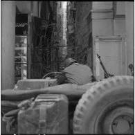 Alger. Journée de deuil du 27 mars 1962. Un soldat à bord d'une jeep devant un barrage de barbelés.