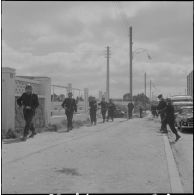 Oran. Fouilles et récupérations d'armes de l'Organisation armée secrète (OAS). Des gendarmes et des soldats en patrouille dans une rue.