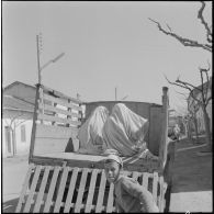 Fondouk. Deux femmes à l'arrière d'un camion avec un enfant au premier plan.