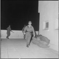 Oran. Mise en place des troupes sur les terrasses. Un soldat dépose des affaires.