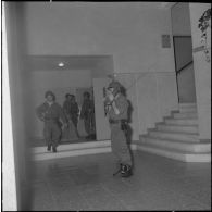 Oran. Mise en place des troupes sur les terrasses. Des soldats à l'intérieur d'un immeuble préparent des sacs.
