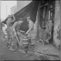 Alger. Quartier des Tagarins. Explosion d'un camion-citerne. Des soldats sortent une bouteille de gaz d'un immeuble.