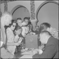 Journée de vote pour le référendum d'autodétermination (1er juillet 1962). Des assesseurs vérifient les identités des votants à l'intéieur d'un bureau de vote.