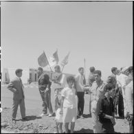 Des civils se préparent pour la cérémonie de lever des couleurs algériennes.