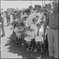 Des enfants parmi la foule attendent la cérémonie de lever des couleurs algériennes.