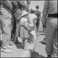 Des enfants parmi la foule attendent la cérémonie de lever des couleurs algériennes.