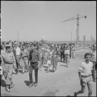 Des civils se préparent pour la cérémonie de lever des couleurs algériennes.