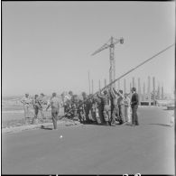 Préparation du poteau pour la cérémonie de lever des couleurs algériennes.