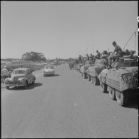 Des soldats de l'armée française à bord d'automitrailleuses Light armored car M8 regardent la population algérienne fêter leur indépendance dans les rues d'Alger.