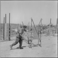 Des soldats effectuent la maintenance d'un barrage électrifié le long de la frontière marocaine dans la région de Tlemcen.