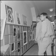 Des officiers visitent une exposition de peinture à la base aérienne 210 (BA 210).