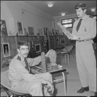Des officiers visitent une exposition de peinture à la base aérienne 210 (BA 210).
